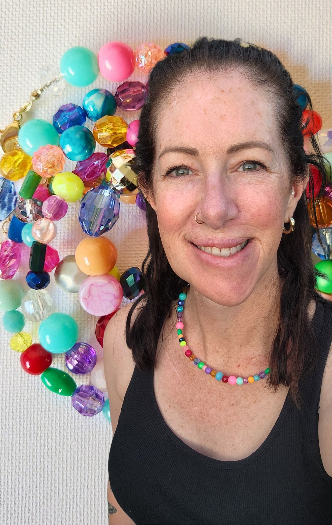 Tara Louise Jewellery designer with a colourful bead background